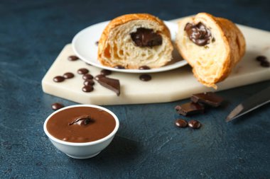 Koyu arkaplanda kesilmiş çikolatalı kruvasan tabağı.