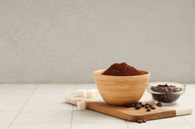 Üzerinde kahve tozu, fasulye ve şeker küpleri olan tahta.