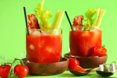 Yeşil arka planda pastırmalı ve kerevizli Bloody Mary kokteyli.