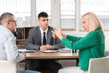 Olgun kadın boşanma avukatının ofisinde kocasıyla alyansını çıkarıyor.