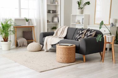 Oturma odasının içinde kanepe, sepet ve raf üniteleri var.