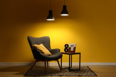 Gri koltuklu, kahve masalı ve geceleri parlayan lambalı şık bir oturma odası.