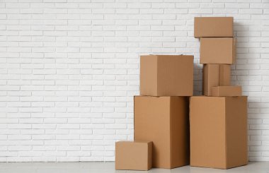 Oturma odasındaki beyaz tuğla duvarın yanında bir sürü farklı paket var.