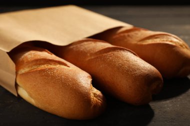 Siyah ahşap masada taze baget torbası, yakın plan.