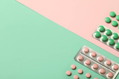 Renkli arka planda su toplayan farklı haplar, yakın plan.