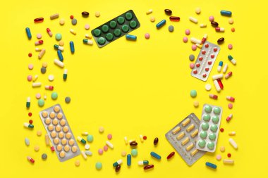 Sarı arka planda farklı haplardan yapılmış çerçeve