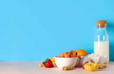 Masada mavi arka planda farklı ürünler var. Gıda Alerjisi Bilinci Ayı