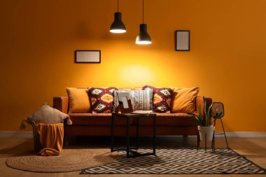 Geceleri kanepede, masada ve parlayan lambalarla oturma odasının içinde.