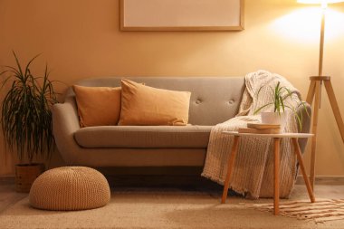 Gri kanepeli, sehpalı ve akşamları parlayan standart lambalı şık bir oturma odası.