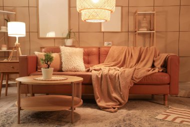 Kahverengi kanepesi, sehpası ve akşam lambaları olan şık bir oturma odası.