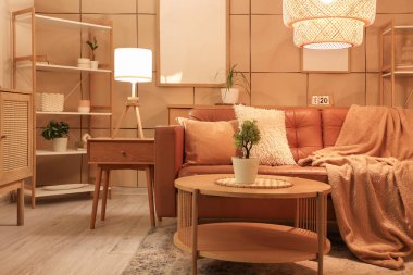 Kahverengi kanepesi, sehpası ve akşam lambaları olan şık bir oturma odası.