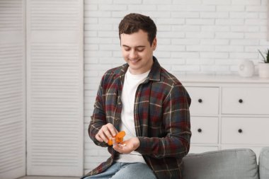 Mutlu genç adam evde hap alıyor.