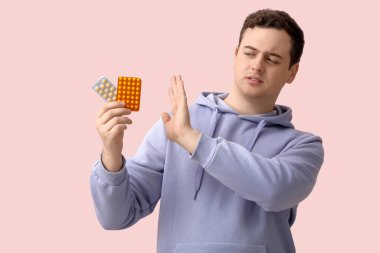 Pembe arka planda dur hareketi gösteren hap kabarcıkları olan genç bir adam.
