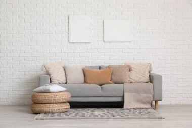 Gri kanepeli, puflu ve resimli oturma odasının içi.