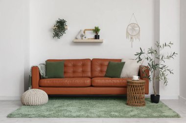 Kahverengi deri kanepe ve yumuşak puf ile modern oturma odası.