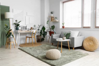 Gri kanepeli ve rahat işyeri olan bir oda.