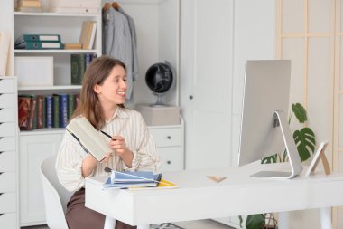 Not defteri olan bayan öğretmen evde online ders veriyor.