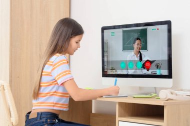 Genç kız, masada öğretmeniyle matematik eğitimi alıyor.