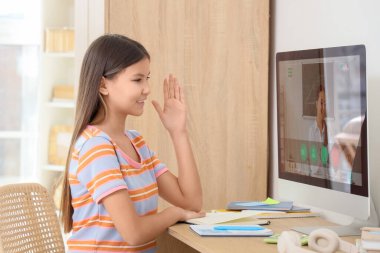 Genç kız, masada öğretmeniyle matematik eğitimi alıyor.