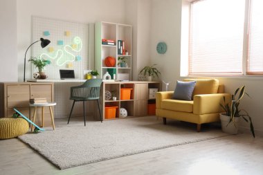 İş yeri, raf ünitesi ve koltuğu olan bir gencin odası.