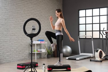 Sportif kadın blogcu spor salonunda aerobik videosu kaydediyor