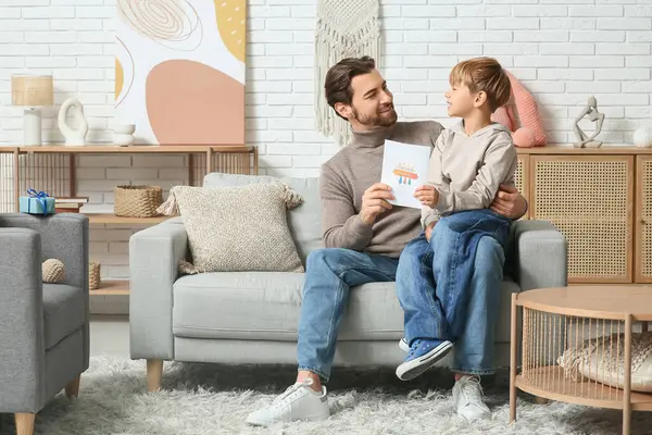 Sevimli küçük oğlan babasına tebrik kartı veriyor. Babalar Günü.