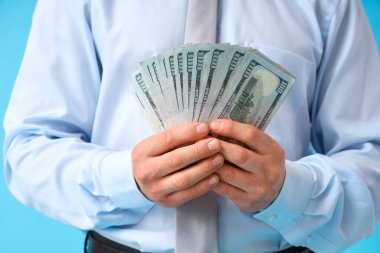 İşadamı mavi arkaplanda para sayıyor, yakın plan.