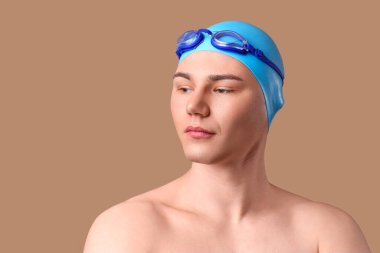 Kahverengi arka planda erkek yüzücü