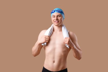 Kahverengi arka planda havlusu olan erkek yüzücü