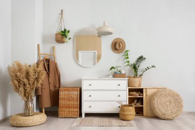 Ayna, palto ve hasır sepetli şık koridorun içi.