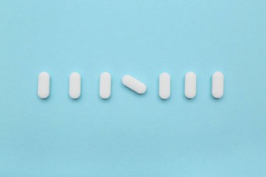 Mavi arka planda bir sürü beyaz hap