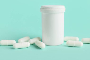 Turkuaz arka planda beyaz sert kapsüllü kavanoz