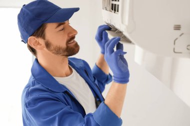 Erkek teknisyen odada klima tamir ediyor, yakın plan.