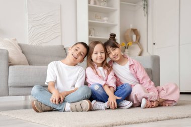 Evdeki halının üzerinde oturan sevimli küçük arkadaşlar.