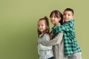 Yeşil arka planda kucaklaşan sevimli küçük arkadaşlar.