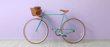 Leylak duvarının yanında hasır sepeti olan modern bisiklet.