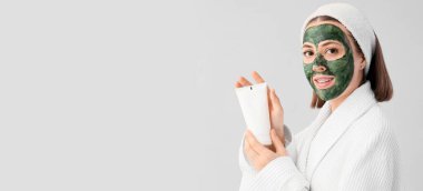 Yüzünde spirulina maskesi olan, açık arkaplan ve metin için yeri olan genç bir kadın.