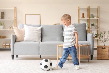 Evde futbol oynayan sevimli küçük çocuk.