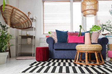 Mavi kanepesi, raf ünitesi ve bitkileri olan şık bir oturma odası.