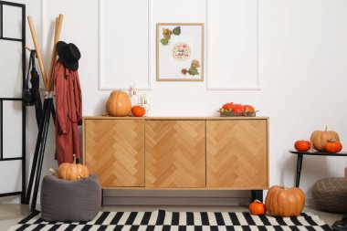 Çekmeceler, puf, askı, balkabaklı kahve masası ve koridorun iç tarafında sonbahar yaprakları.