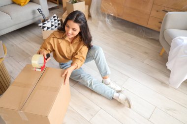 Güzel bir kadın taşınma gününde odada kayıt yapıyor.