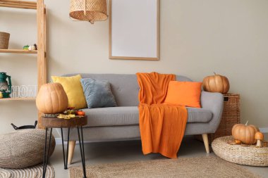 Kanepesi, raf ünitesi ve sonbahar dekoru olan rahat bir oturma odası.