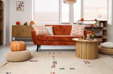 Sonbahar dekoru, kanepesi ve masası olan bir oturma odası.