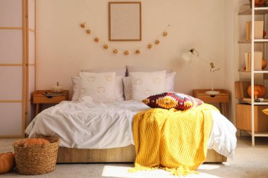 İçinde raf ünitesi, boş çerçeve ve balkabağı olan rahat bir yatak odası.