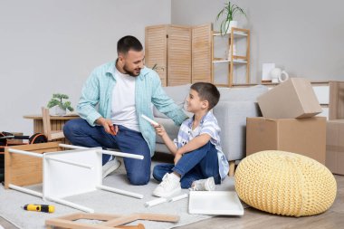 Babası ve tatlı oğlu evde raf montajı yapıyor.