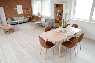 Koltukları, yemek masası ve raf üniteleri olan stüdyo dairesi.