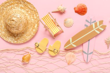 Deniz kabukları ve pembe arka planda farklı plaj dekorları olan bir ağ.