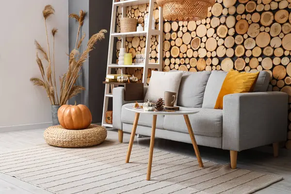 Sonbahar dekoru, kanepesi ve raf ünitesi olan oturma odasının içinde.