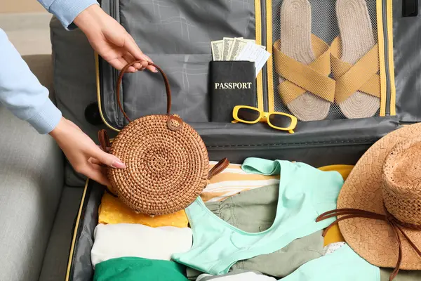 Evdeki kanepede seyahat etmek için el çantalı genç kadın, yakın plan.