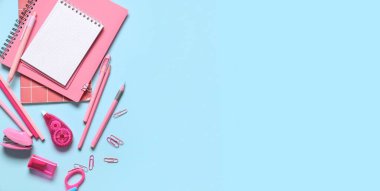 Açık mavi arkaplan üzerine not defterleri ve farklı okul kırtasiyesi